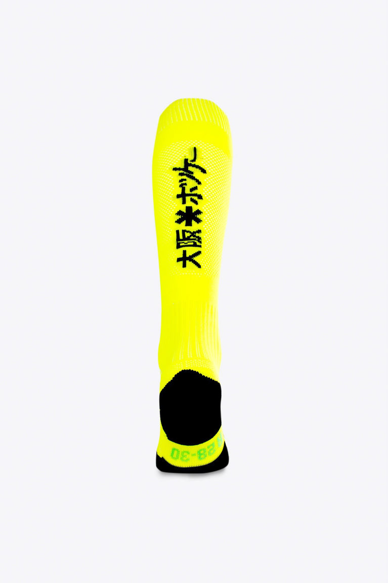 Osaka Field Hockey Socks in yellow with Osaka logo in green. Back view