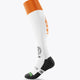 White field hockey socks with orange cuff, orange side logo, and black heel/toe