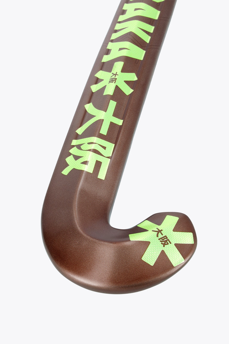 Brown field hockey stick head with green star graphics and curved blade.