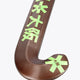 Brown field hockey stick head with green star graphics and curved blade.