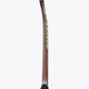 Brown field hockey stick with green accents and a black grip on the handle.