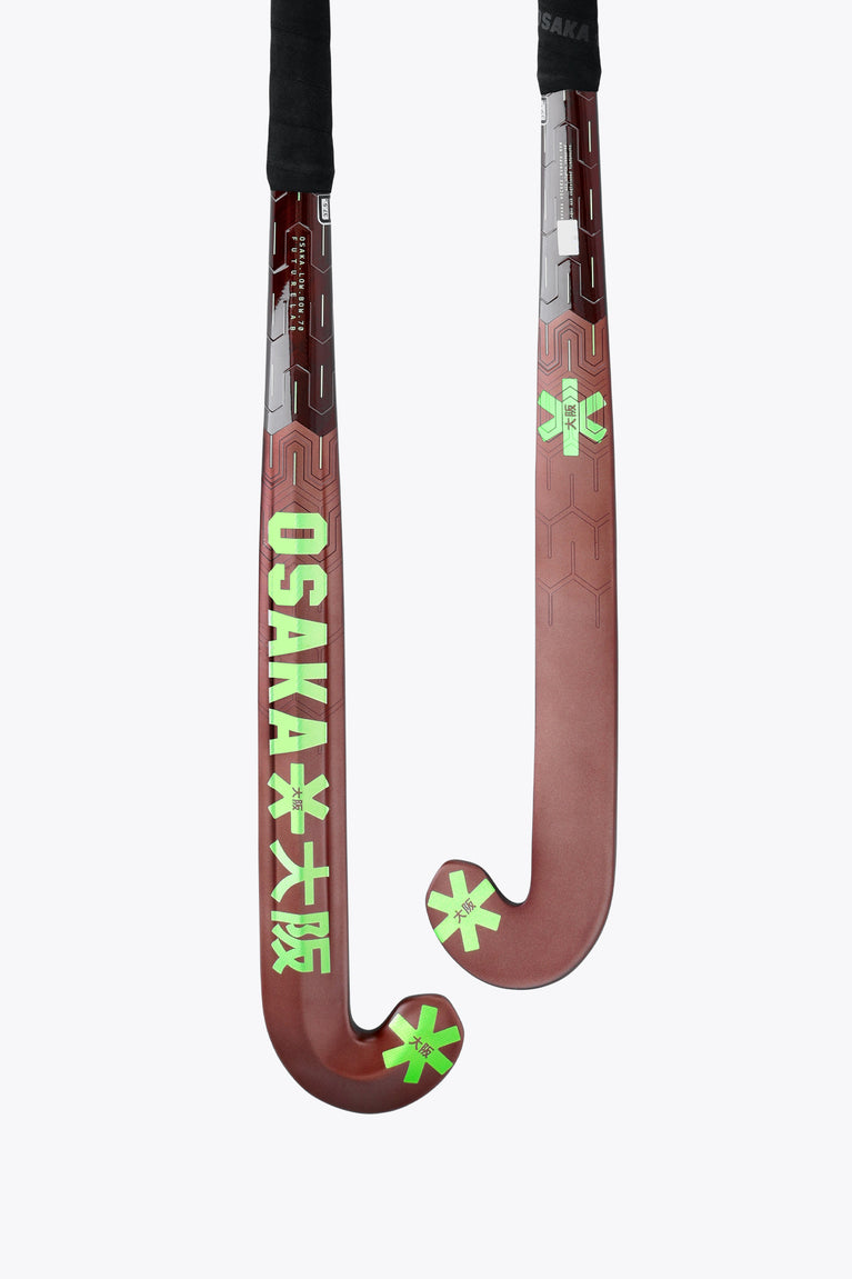Field hockey stick pair view: dark brown blade with lime star accents and black handle.