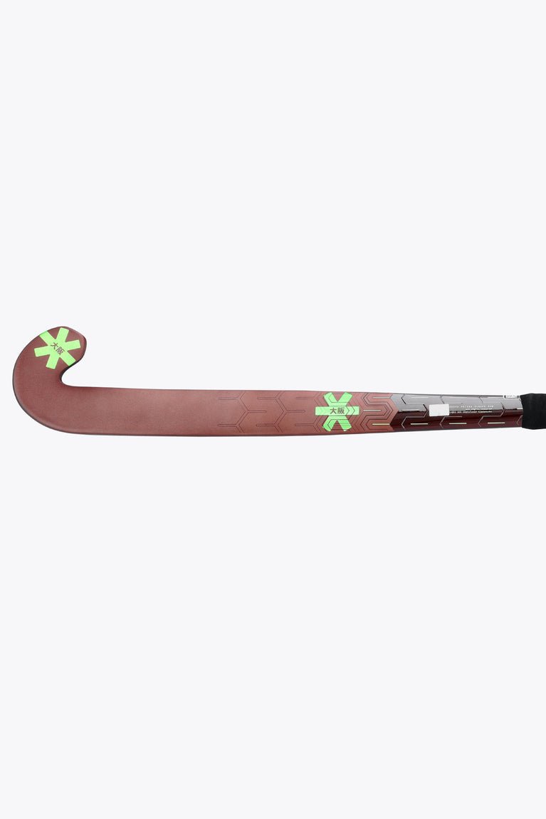 Field hockey stick with dark brown low-bow head and lime graphics, black grip.