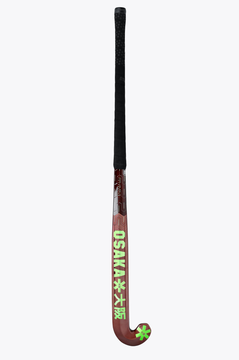 Field hockey stick upright view: dark brown blade with lime cross/star accents and black handle.