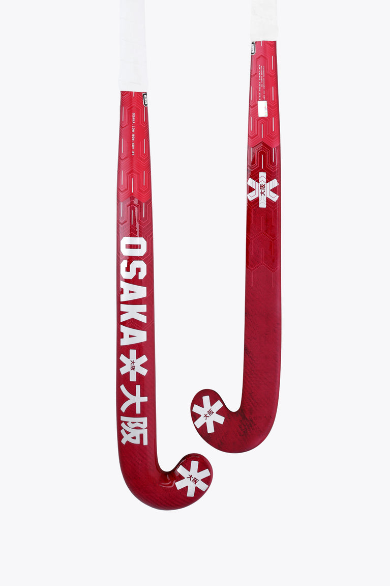 Hot pink field hockey stick with curved blade and white grip at the end