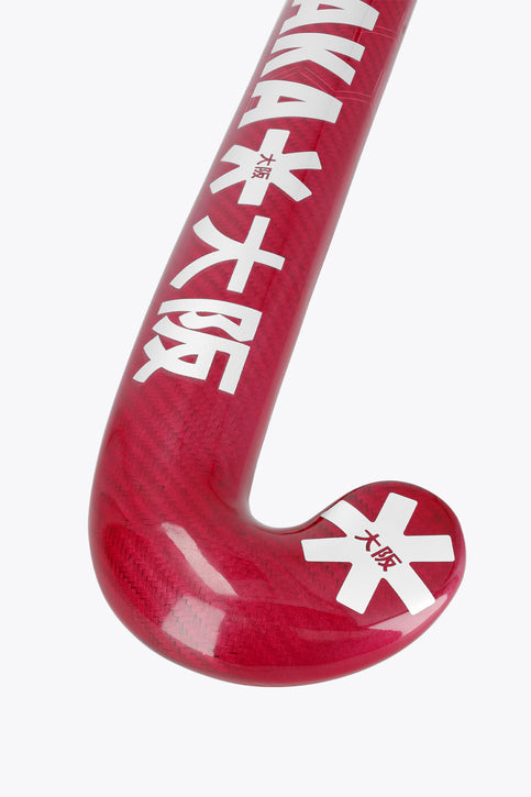 Hot pink field hockey stick with curved blade and white grip at the end