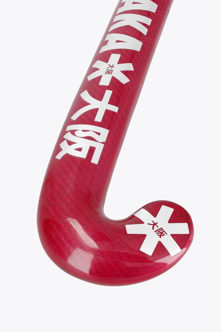 Hot pink curved field hockey blade with printed star logos and textured surface