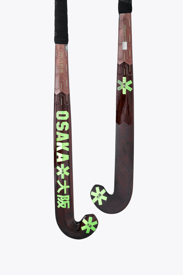 Field hockey stick shaft with OSAKA text and green star graphics, black grip