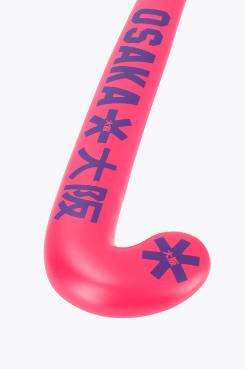 Hot pink mid-bow field hockey stick with patterned grip at the handle