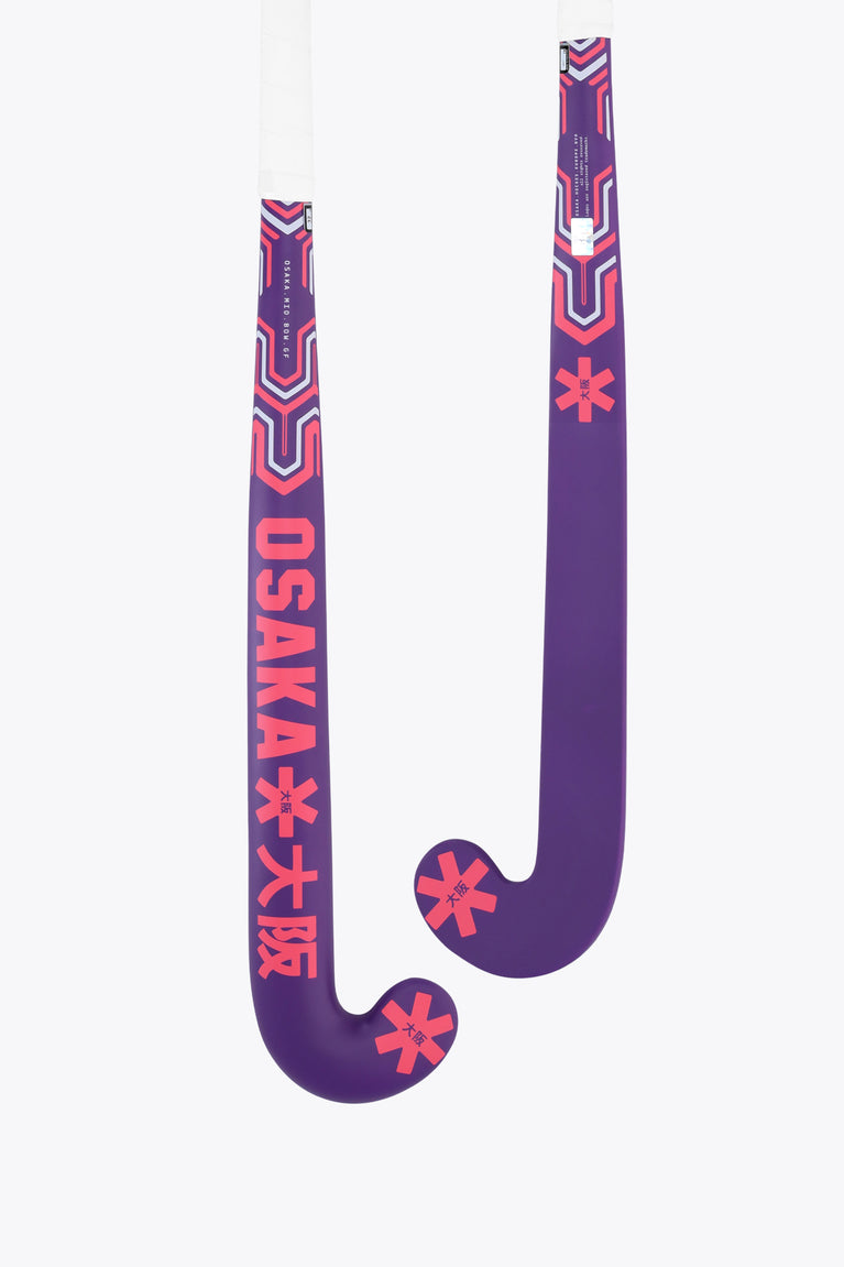 Royal purple field hockey stick with red geometric graphics, mid-bow curved head.