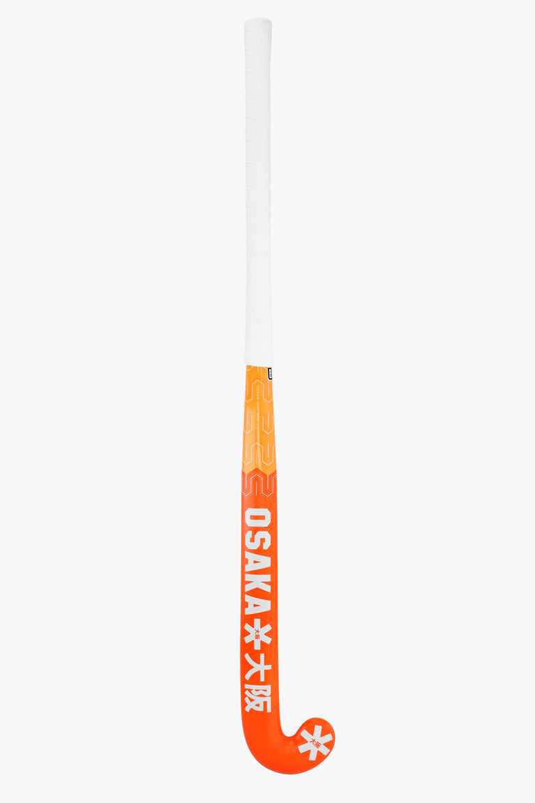 Orange field hockey stick with white shaft cap and red patterned grip area