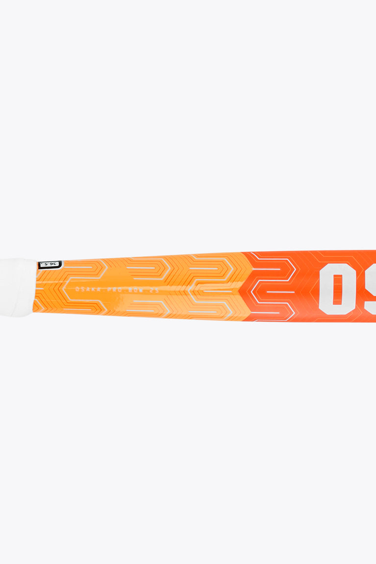 Orange field hockey stick shaft close-up with geometric pattern and OS logo