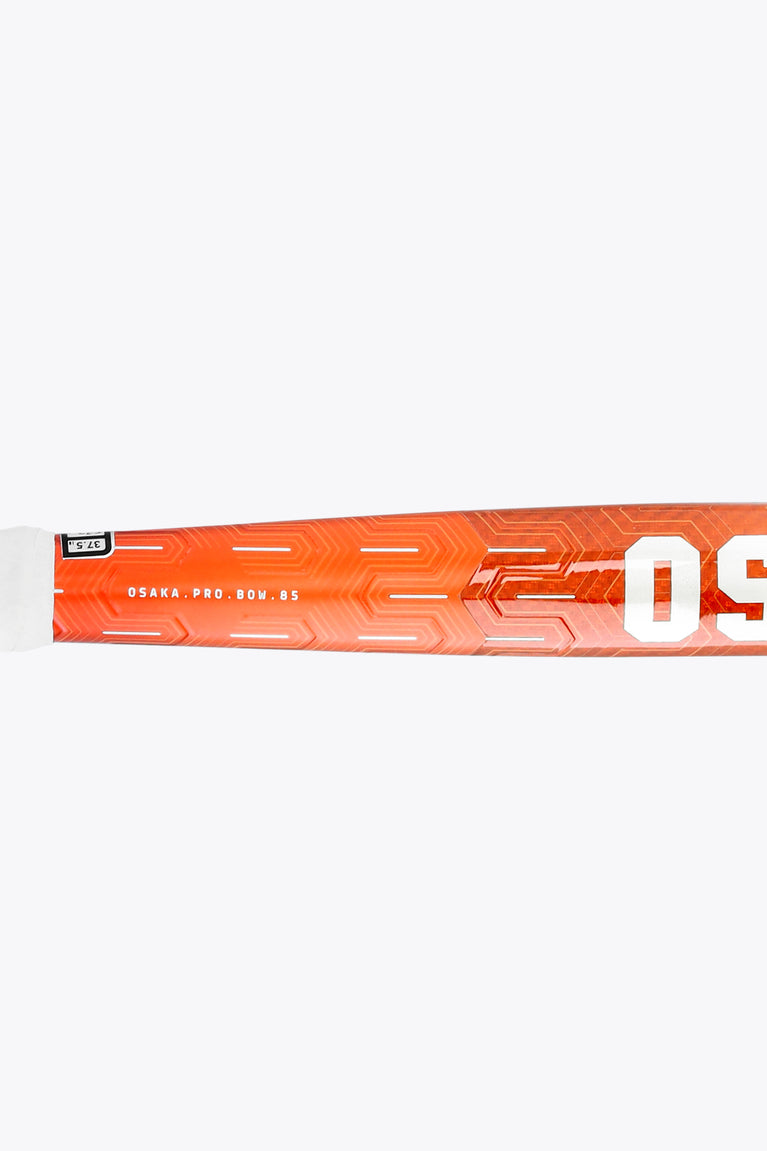 Bright orange field hockey stick shaft with patterned graphics and OSAKA lettering
