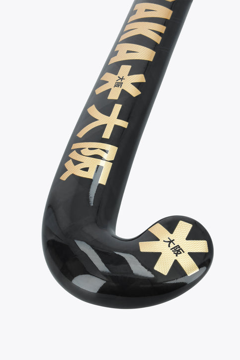 Field hockey stick with dark shaft and gold Osaka graphics on curved blade