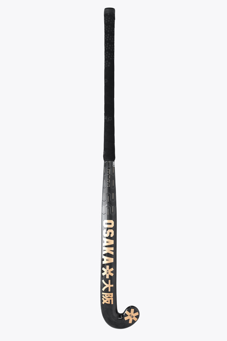 Field hockey stick top grip with textured dark surface and gold branding on shaft