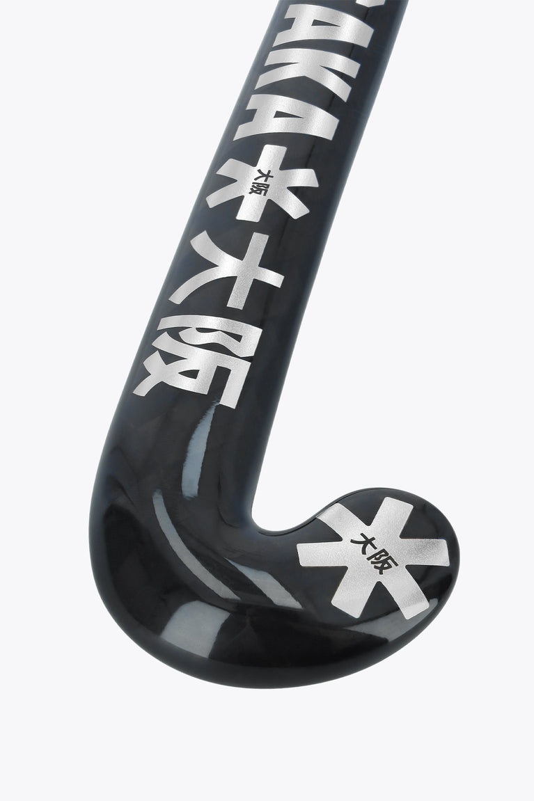 Field hockey stick blade close-up, dark black curve with Osaka branding and star emblem