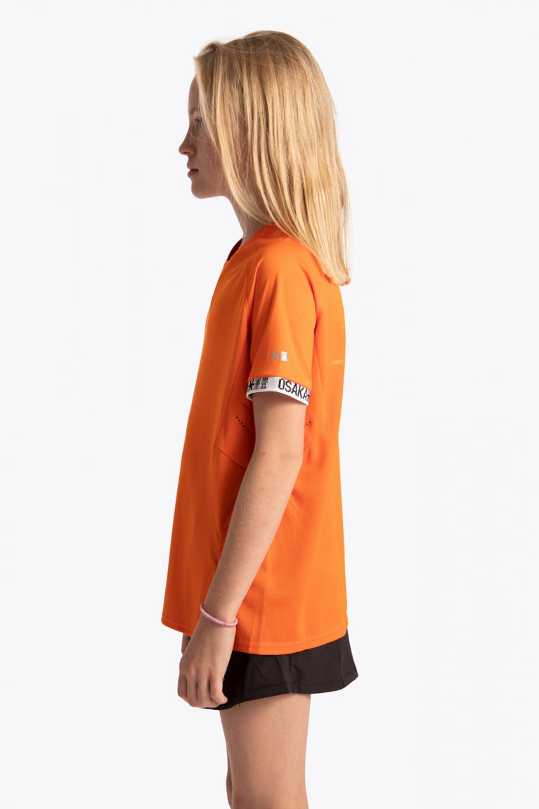 Girl wearing the Osaka Kids Jersey in Orange. Side view