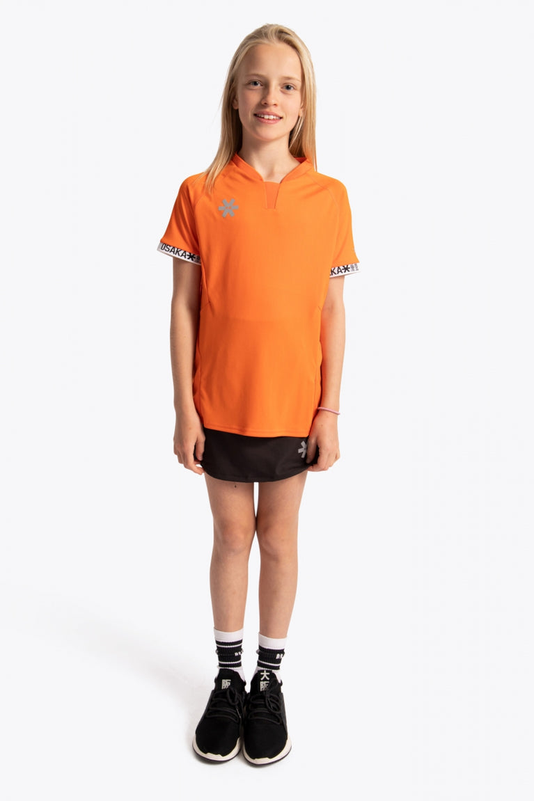 Girl wearing the Osaka Kids Jersey in Orange. Front view