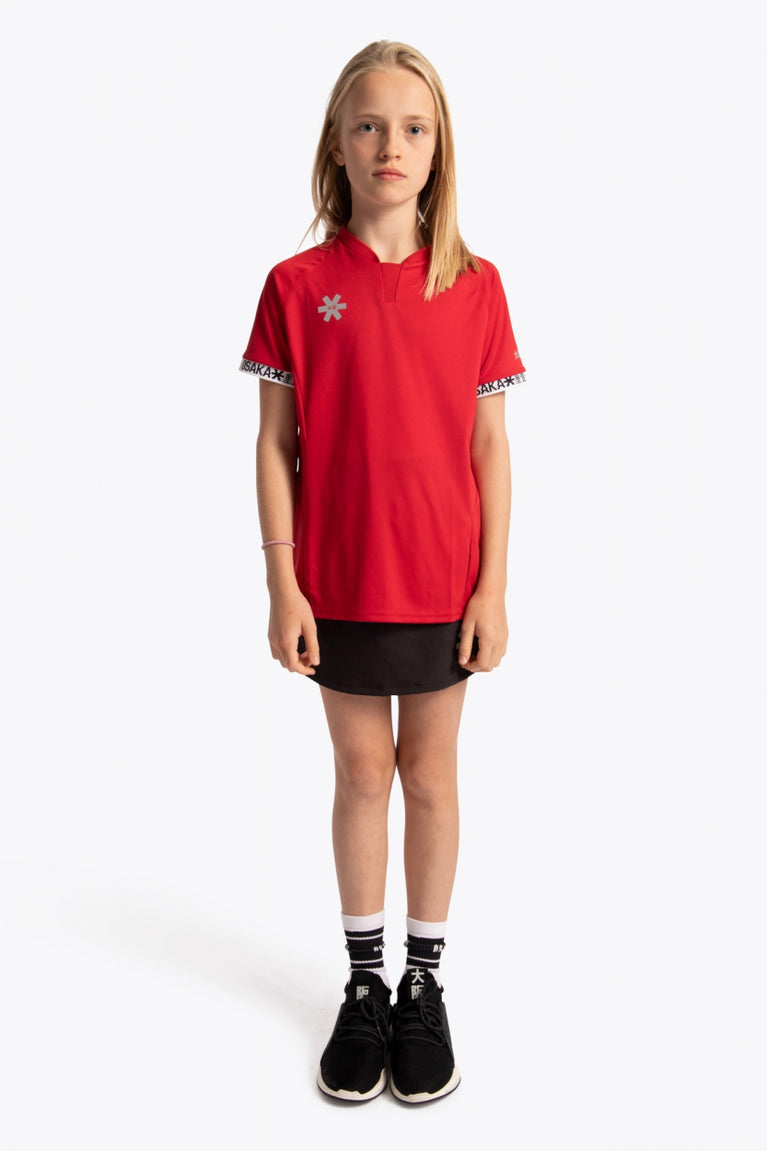 Girl wearing the Osaka Kids Jersey in Red. Front view