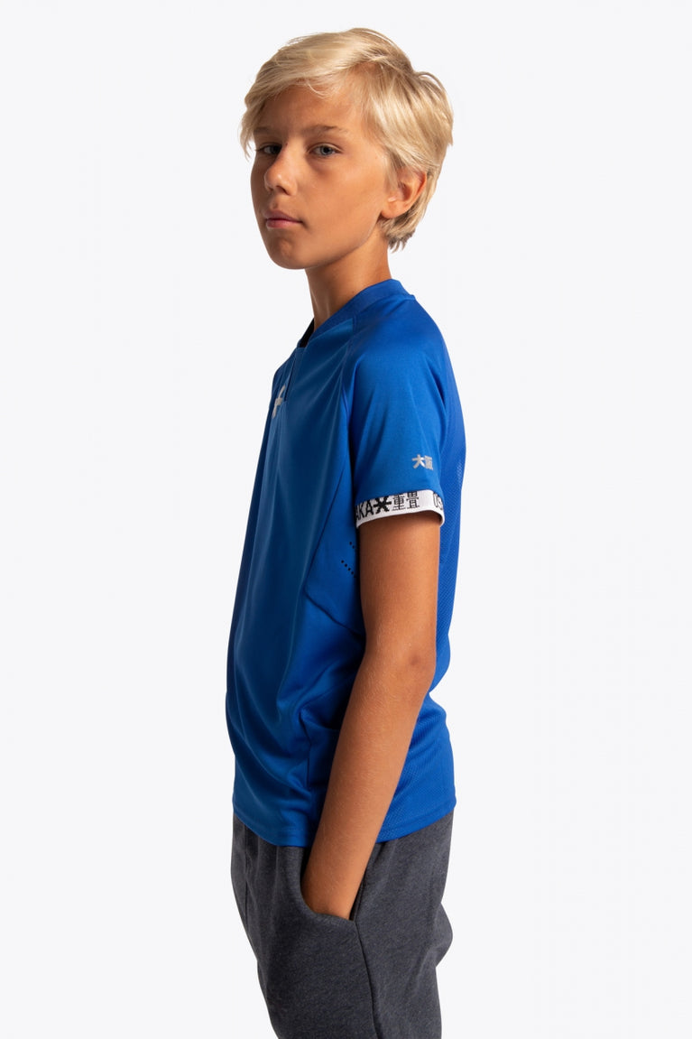 Boy wearing the Osaka Kids Jersey in Royal blue. Side view