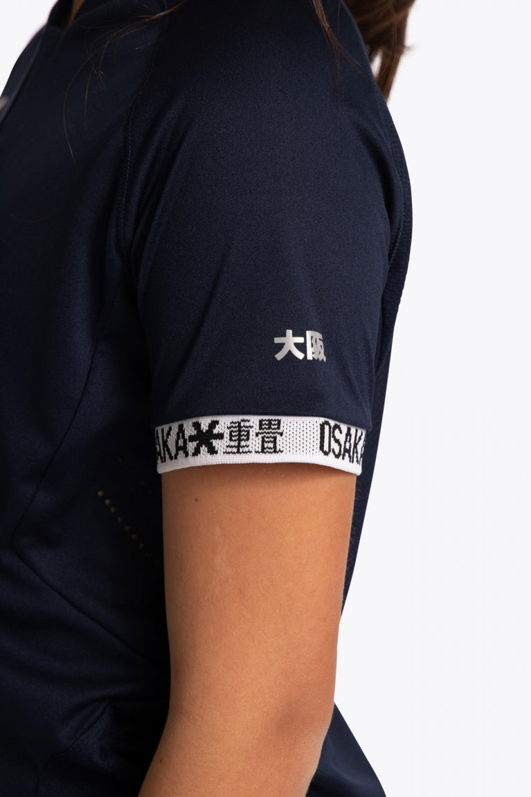 Girl wearing the Osaka Kids Jersey in Navy. Detail sleeve logo view