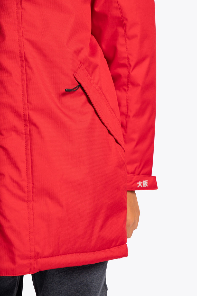 Boy wearing the Osaka Kids Stadium Jacket in Red. Front detail pocket view