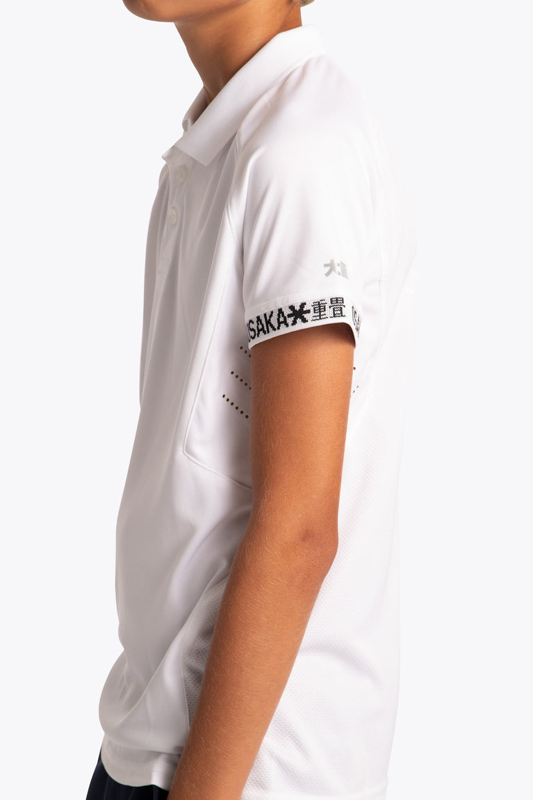 Boy wearing the Osaka Kids Polo Jersey in White. Side logo view