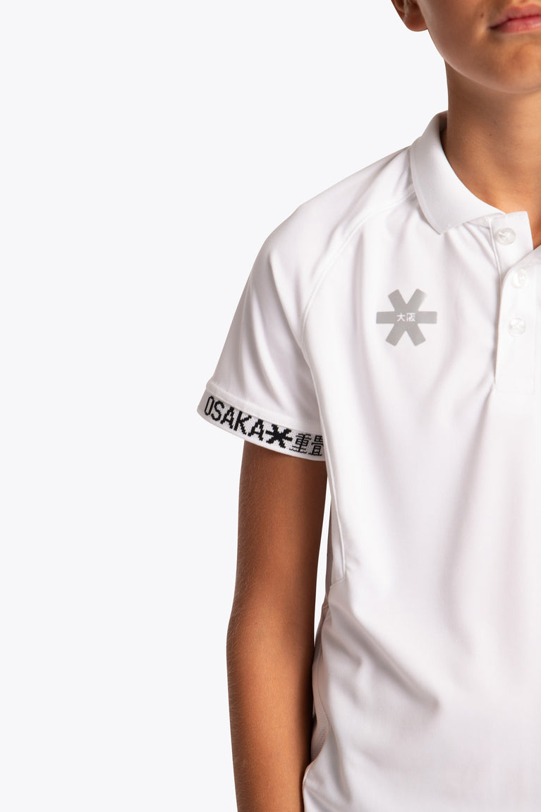 Boy wearing the Osaka Kids Polo Jersey in White. Front detail logo view