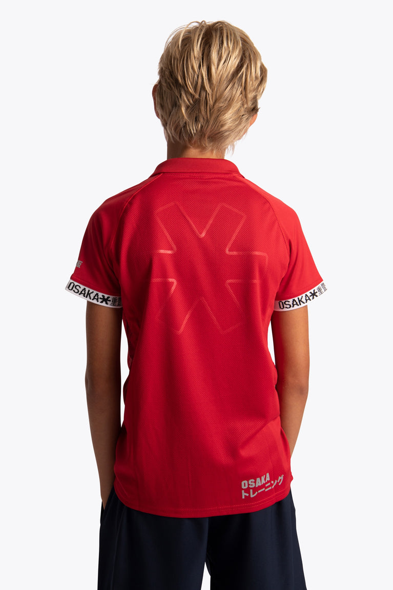 Boy wearing the Osaka Kids Polo Jersey in Red. Back view
