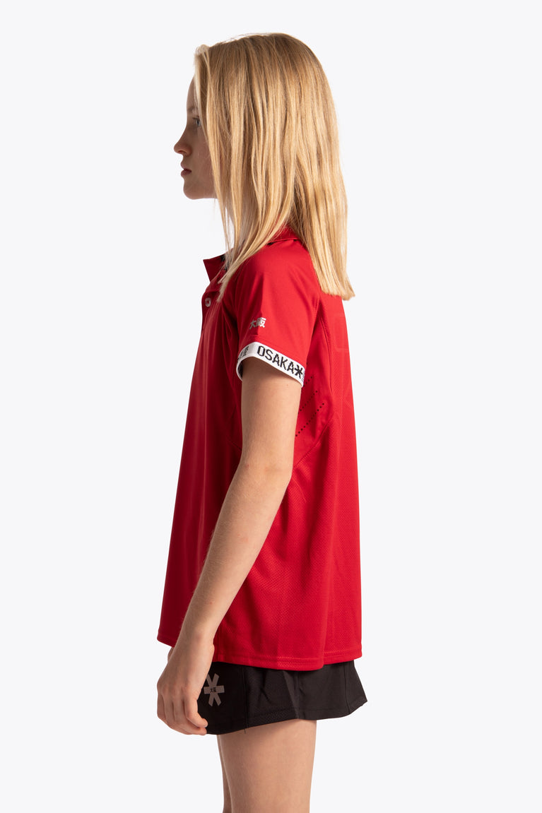Girl wearing the Osaka Kids Polo Jersey in Red. Side view