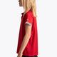 Girl wearing the Osaka Kids Polo Jersey in Red. Side view