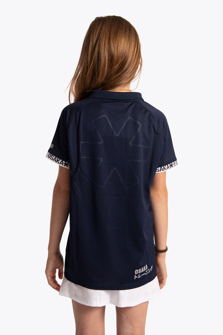 Girl wearing the Osaka Kids Polo Jersey in Navy. Back view