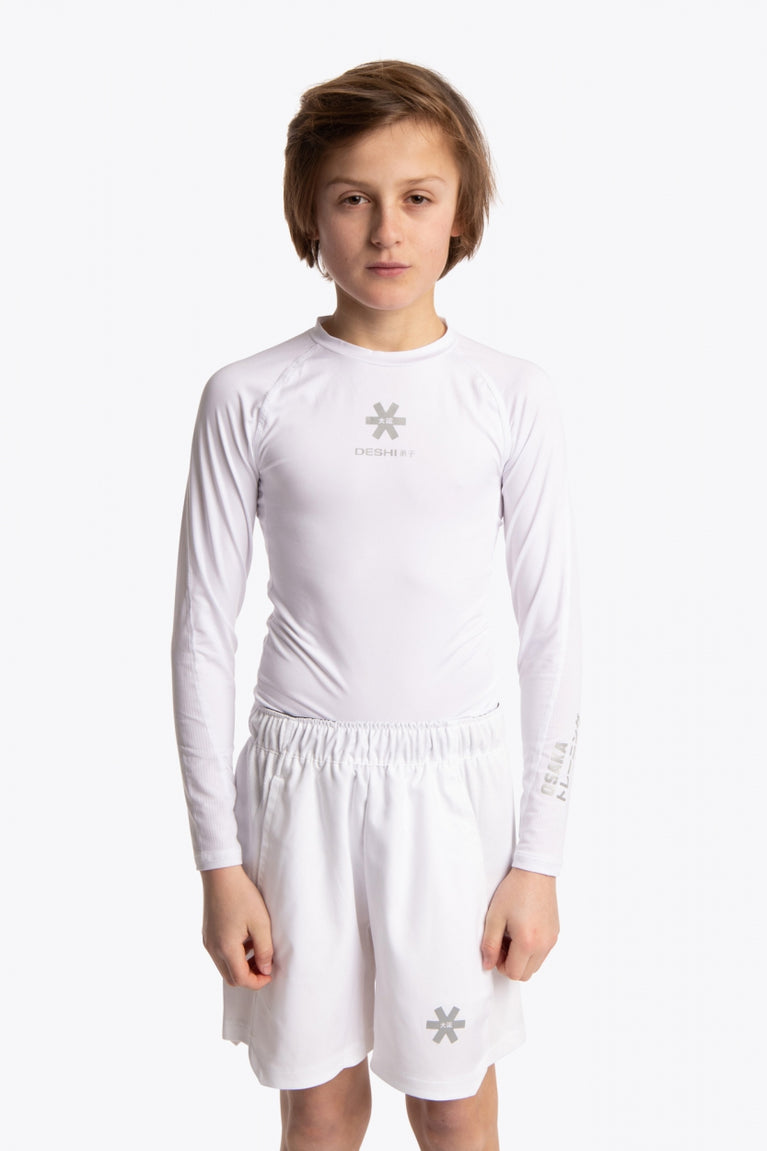 Boy wearing the Osaka Kids Baselayer Top in white. Front view