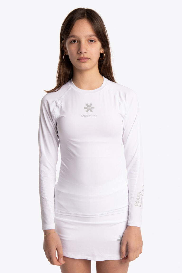 Girl wearing the Osaka Kids Baselayer Top in white. Front view