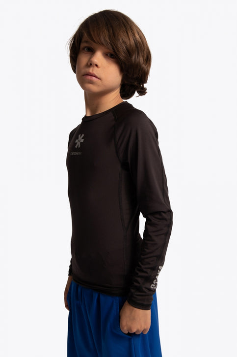 Kid wearing the Osaka Kids Baselayer Top in Black. Front view