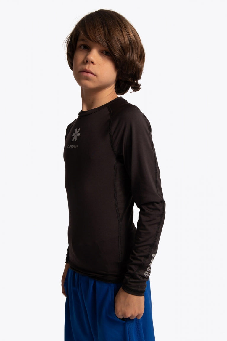 Kid wearing the Osaka Kids Baselayer Top in Black. Side view