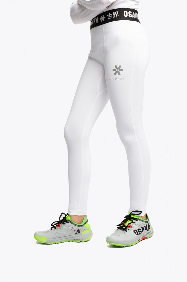Model wearing the Osaka Kids Baselayer Tights in White. Side view