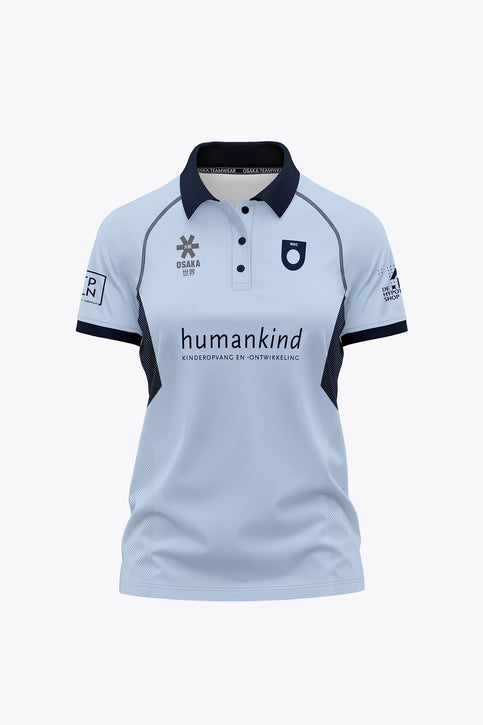 Women’s sky blue polo jersey with navy collar, button placket, and front graphic print