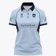 Women’s sky blue polo jersey with navy collar, button placket, and front graphic print