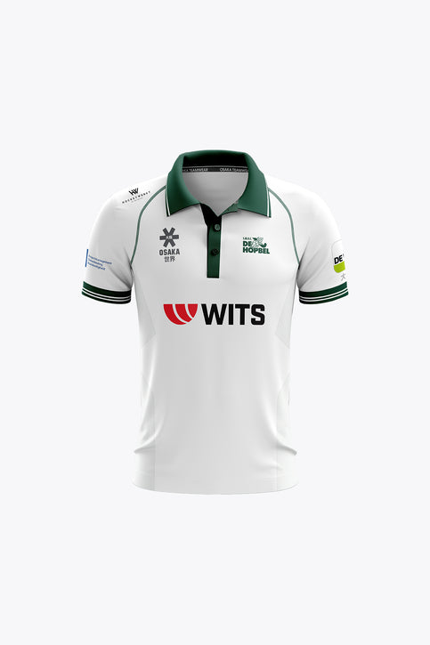 De Hopbel kids polo jersey in white with green collar, striped cuffs, and front logos.