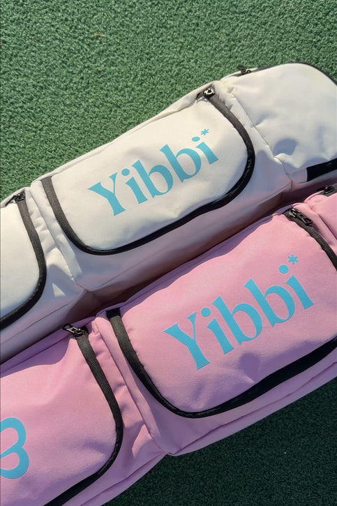 Small pastel pink sports stickbag with two zip front pockets, black trim