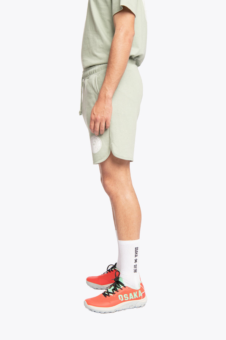 Iceberg green colour Osaka men shorts Elite Society from The Sports Society Collection made for a retro country vintage sport-chic aesthetics. 90s era ode style for that on-and off-field lifestyle. Left side view below shoulders view of model